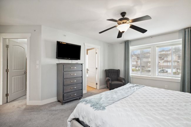 Bedroom with light colored carpet, baseboards, a ceiling fan, and connected bathroom | Image 19
