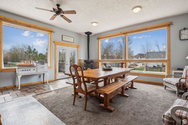 Dining room featuring ceiling fan, baseboards, and a wood stove | Image 17