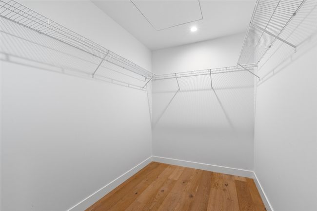 Spacious closet with light wood finished floors | Image 11