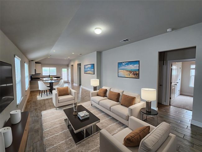 Living area featuring wood finish floors, plenty of natural light, lofted ceiling, and recessed lighting | Image 5