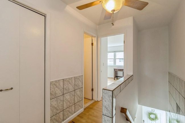 Hall with light wood finished floors and tile walls | Image 14