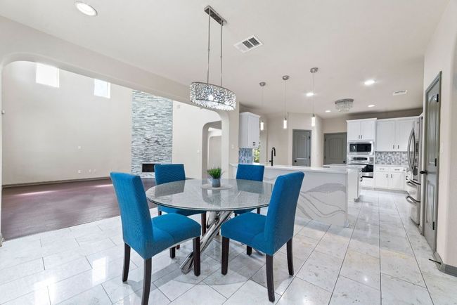 Dining area with arched walkways, recessed lighting, and light tile patterned flooring | Image 15
