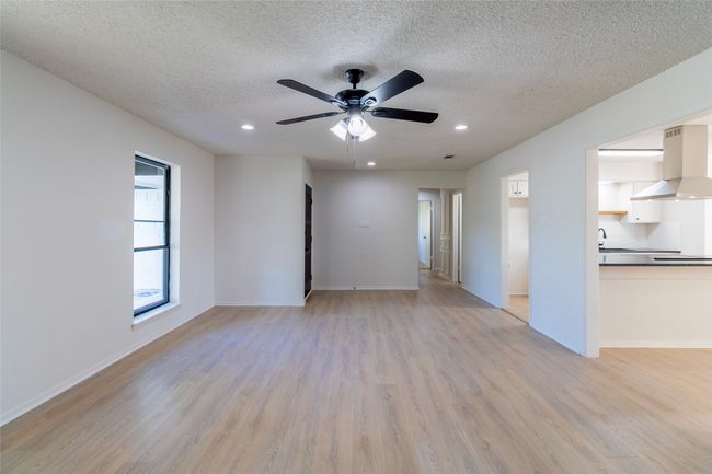 Unfurnished living room with recessed lighting, light wood-type flooring, a textured ceiling, and ceiling fan | Image 16