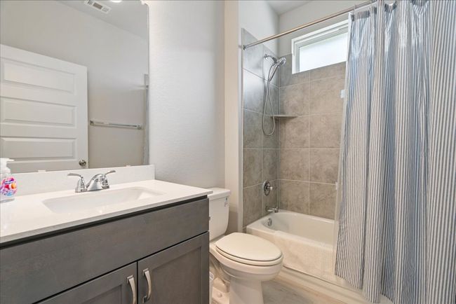 Bathroom featuring vanity and shower / bathtub combination with curtain | Image 19