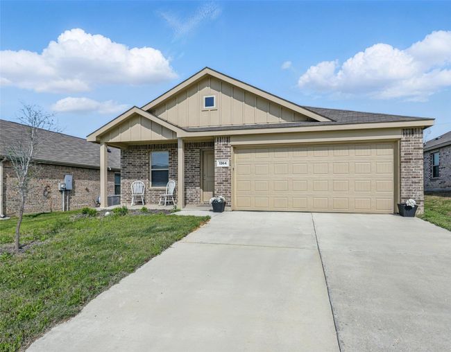 View of front of home featuring concrete driveway, covered porch, an attached garage, a front yard, and brick siding | Image 16