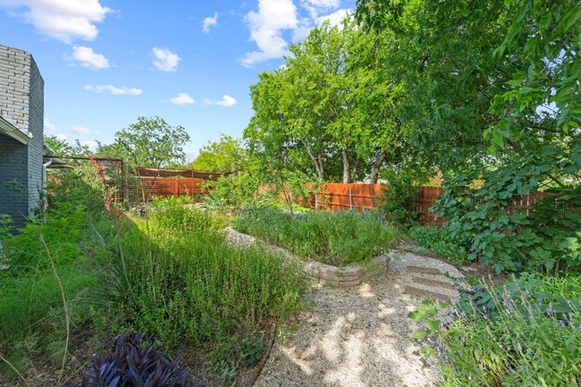 The spectacular backyard oasis is a colorful landscape bursting with native plants and irrigated by sustainable rainwater catchment systems with irrigation systems for the lush plant beds. | Image 36