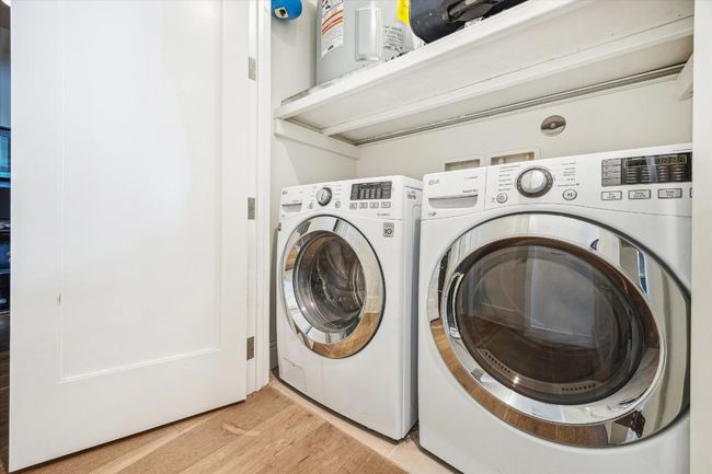 Laundry room featuring washing machine and dryer, laundry area, and light wood-style flooring | Image 13
