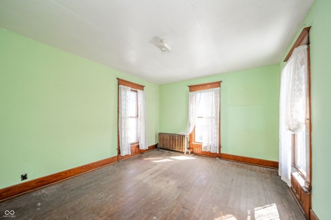 spare room featuring wood-type flooring, baseboards, and radiator | Image 16