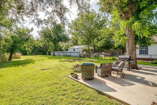 View of yard featuring Large patio and view of wooded area | Image 29