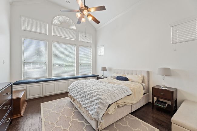 Bedroom with dark wood-style floors, ornamental molding, high vaulted ceiling, and ceiling fan | Image 18