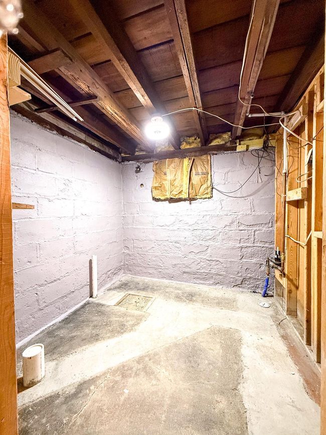 Unfinished area has drains installed to support a future bathroom | Image 36