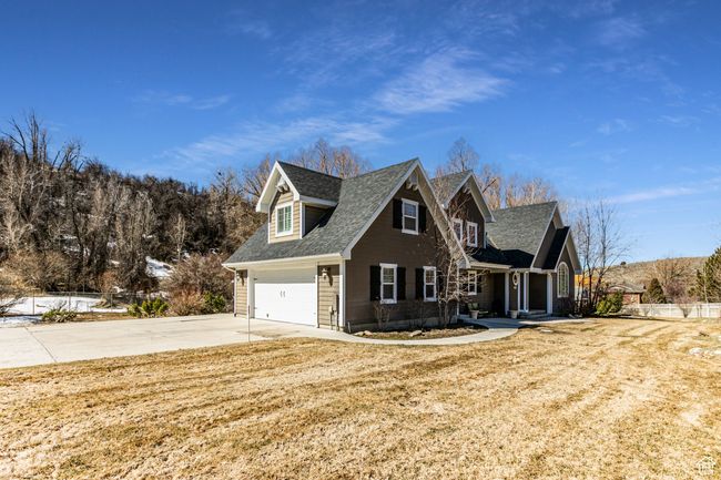 View of front facade featuring a front yard, concrete driveway, and roof with shingles | Image 51