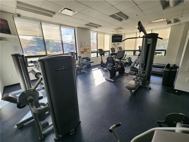 Fitness center in clubhouse features cardio equipment and weights | Image 17