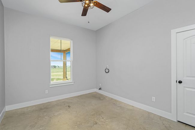 Unfurnished room featuring concrete floors, a ceiling fan, and baseboards | Image 15