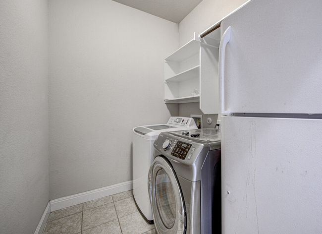 Laundry area featuring washer and dryer and light tile patterned floors | Image 6