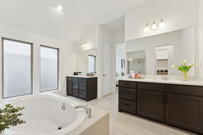 Full bath with lofted ceiling, a garden tub, two vanities, and a tile shower | Image 21