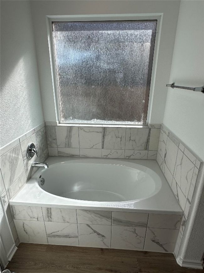 Bathroom with wood finished floors and a bath | Image 16
