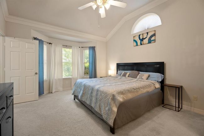 Your primary bedroom lets in so much natural light from the wall of windows. | Image 11