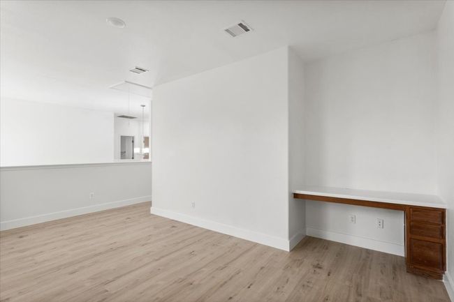 Unfurnished room with wood finished floors, attic access, and built in study area | Image 16