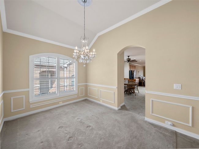 Empty room featuring arched walkways, lofted ceiling, carpet, crown molding, and a decorative wall | Image 6