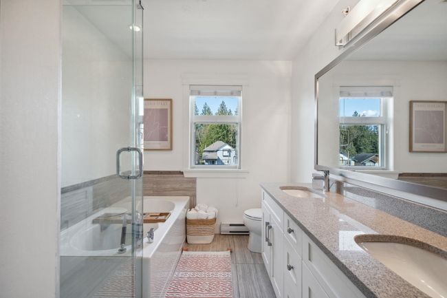 Bathroom featuring a sink, toilet, a stall shower, and a bath | Image 20