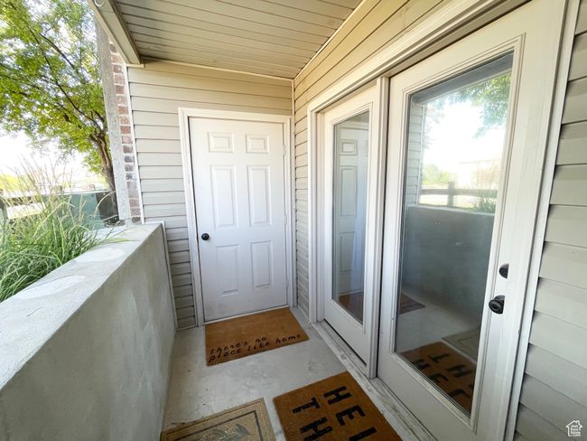 Doorway to property with a covered patio and storage space | Image 20