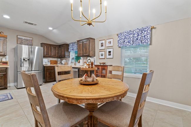Dining area featuring vaulted ceiling, a chandelier, recessed lighting, and light tile patterned floors | Image 11