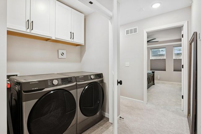 Convenient upstairs hallway washer and dryer closet—no more hauling laundry up and down stairs, plus plenty of storage space to keep essentials organized. | Image 34