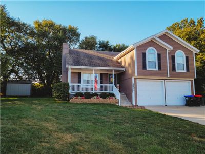 Front of home with a covered porch, 2 car garage and 3rd car driveway. | Image 1