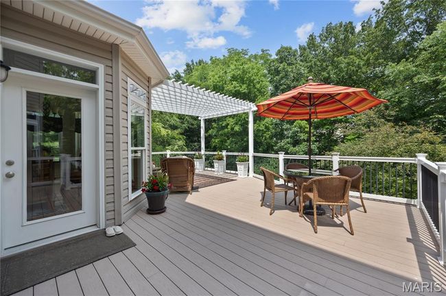 Wooden deck with a pergola, outdoor dining area, and view of scattered trees | Image 61
