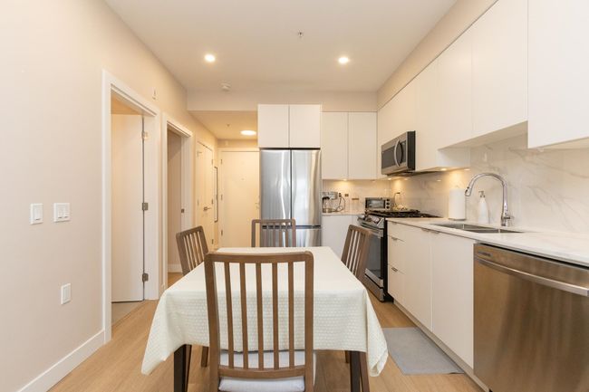 Kitchen featuring white cabinetry, light wood-style flooring, a sink, and stainless steel appliances | Image 11