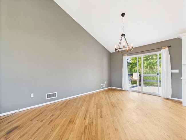Spare room with light wood-type flooring, a chandelier, and high vaulted ceiling | Image 17