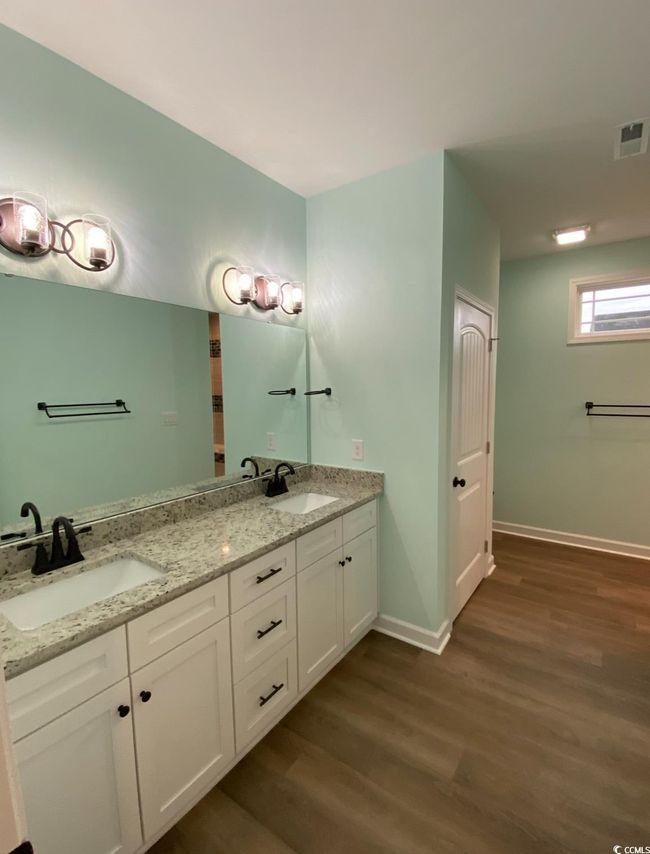 Full bathroom featuring wood finished floors, double vanity, and baseboards | Image 7