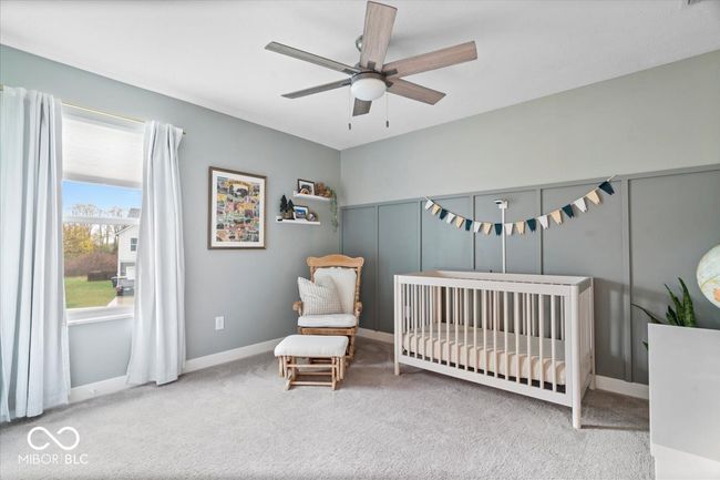carpeted bedroom with a crib and ceiling fan | Image 31