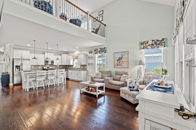 Living room featuring a high ceiling, dark wood-style floors, and recessed lighting | Image 13