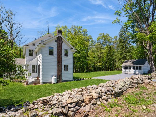 View of side of home with a chimney, a yard, and a detached garage | Image 6