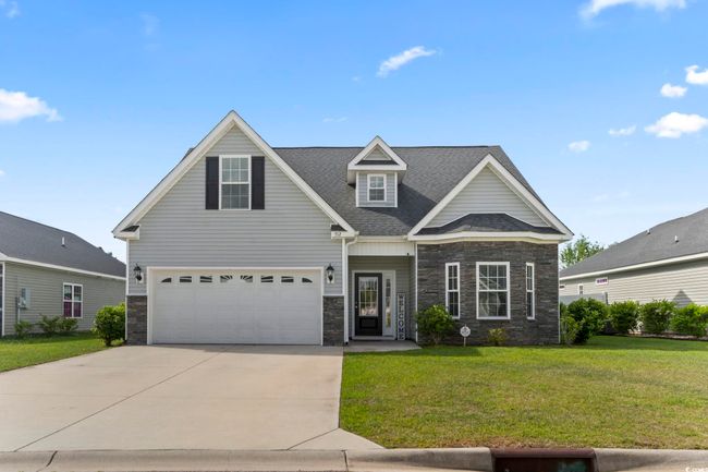 View of front facade featuring driveway, roof with shingles, a front yard, a garage, and stone siding | Image 38
