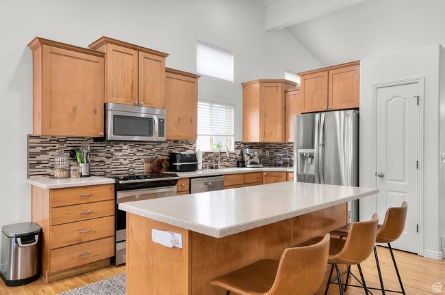 Kitchen featuring stainless steel appliances, light countertops, beam ceiling, and large island | Image 5