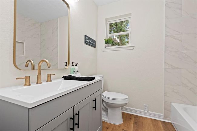 Secondary bathroom- new vanity, faucets and hardware, luxury vinyl plank flooring, tile surround, etc. | Image 16