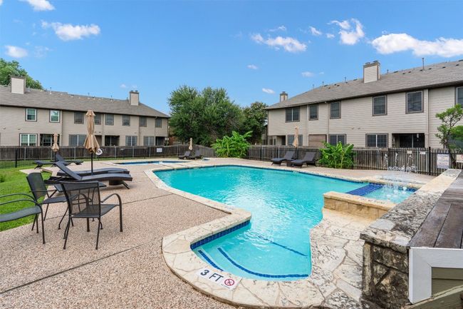 Community pool featuring a hot tub, a patio area, a fenced backyard, and a residential view | Image 19