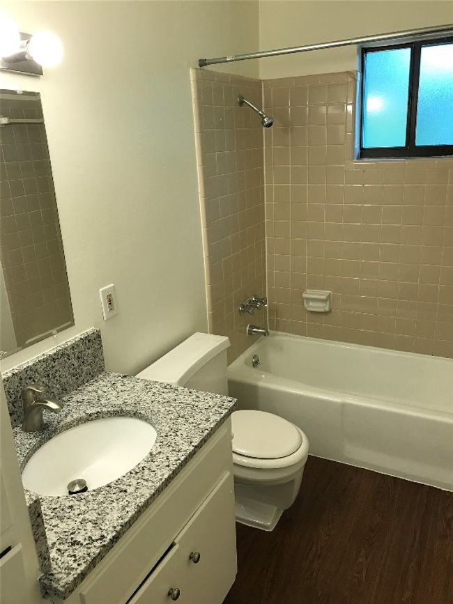 Full bathroom with toilet, shower combination, wood finished floors, and vanity | Image 5