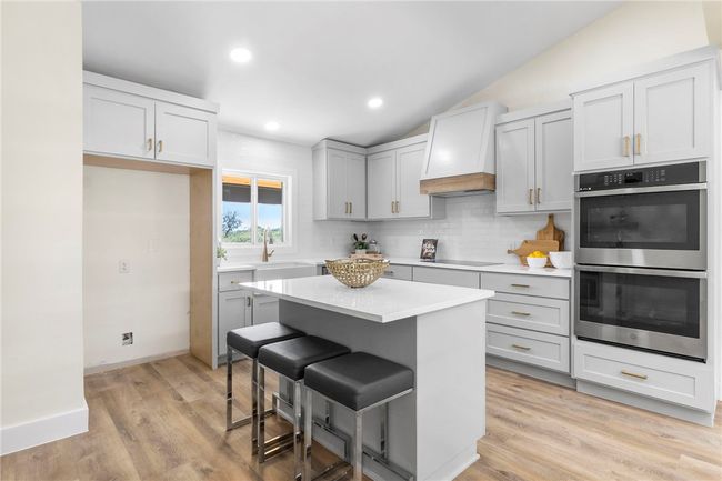 The kitchen generously hosts a center island and breakfast bar where guests can sit and mingle with the cook. | Image 14