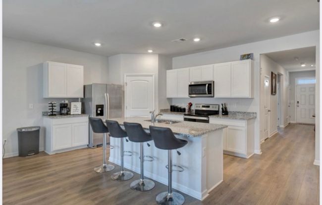 Beautiful kitchen with coffee bar and island separates open dining area. Great entertaining and family space, without being crowded. | Image 8