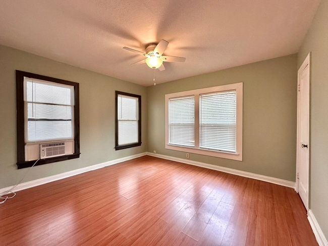 Bedroom with a ceiling fan, wood finished floors, and cooling unit | Image 9