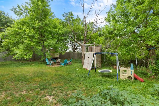 View of yard featuring a playground and an outdoor fire pit | Image 34