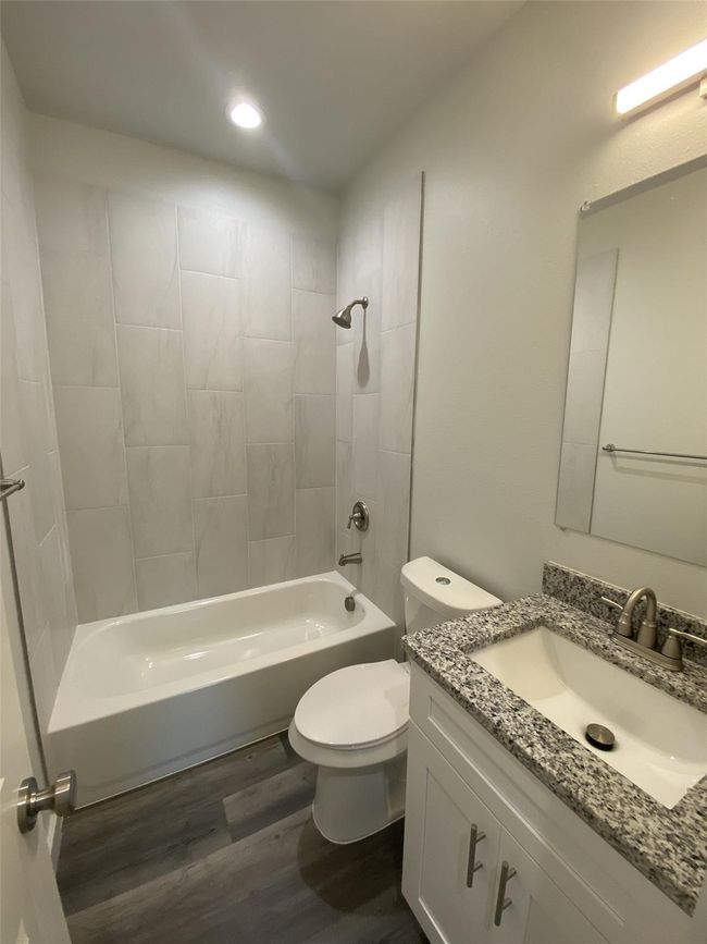 Full bath with toilet, vanity, wood finished floors, bathing tub / shower combination, and recessed lighting | Image 12