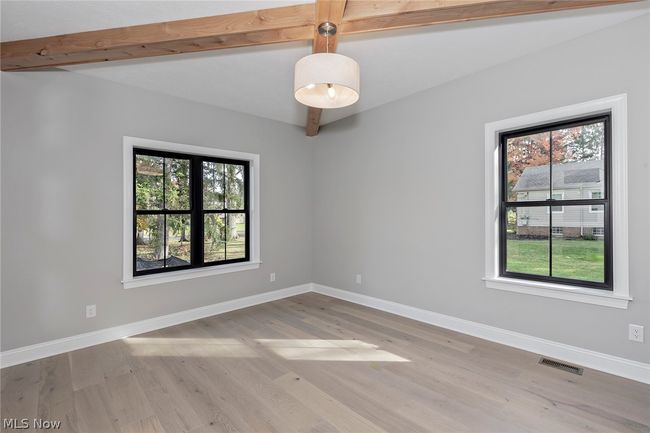 Empty room featuring a healthy amount of sunlight, beamed ceiling, and light hardwood / wood-style floors | Image 9