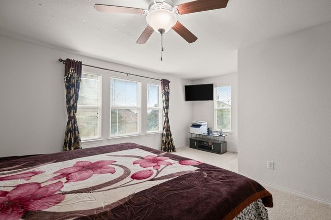 Carpeted bedroom featuring multiple windows and ceiling fan | Image 15