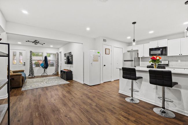 Kitchen with appliances with stainless steel finishes, open floor plan, light countertops, white cabinets, and recessed lighting | Image 16