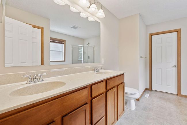 The primary bath has a dual vanity with storage underneath | Image 13